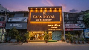 Un edificio con un cartel que indica 'CASA ROYAL RESIDENCY' y 'PREMIUM ROOMS' en varios idiomas.