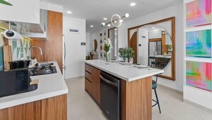 Una cucina moderna con isola centrale, mobili in legno e lavastoviglie integrata.