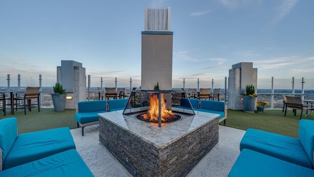 A rooftop terrace with a fire pit, blue seating, and a view of the cityscape. - Cozy 1-bedroom apartment with AC in marvelous Raleigh (Raleigh)