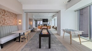 A modern lounge area with a foosball table, seating, and a fireplace. - Cozy 1-bedroom apartment with AC in marvelous Raleigh (Raleigh)