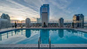 A rooftop pool with a clear view of the city skyline, including modern buildings and a sunset. - Cozy 1-bedroom apartment with AC in marvelous Raleigh (Raleigh)