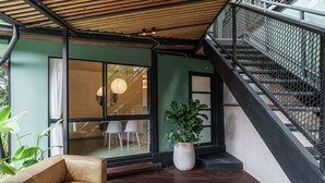 Ein modernes Interieur mit Holzbalkendecke, einer Treppe, einem Sofa und einer Topfpflanze.