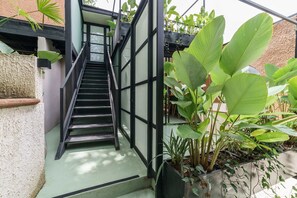 A staircase with black railings leading to a covered area with potted plants. - w Attractive 2BR w Balcony in Poblado (Medellín)