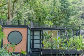 A modern building with a staircase, surrounded by lush greenery and a large circular window. - w Attractive 2BR w Balcony in Poblado (Medellín)