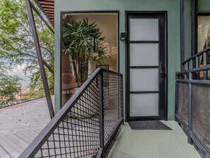 A staircase leading to a door with a metal railing, a potted plant, and a view of the street. - w Attractive 2BR w Balcony in Poblado (Medellín)