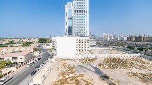 Un immeuble moderne de grande hauteur, doté d’une façade vitrée remarquable, situé dans un quartier urbain sous un ciel dégagé.
