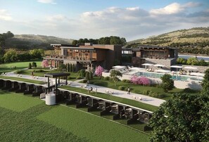 Een modern hotel met een zwembad, terras en uitzicht op het omliggende landschap.