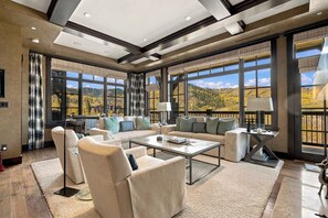 A spacious living room with a large window offering a mountain view, a fireplace, and a cozy seating area. - Ski-in/Ski-out Luxury 3-Bedroom Retreat at Flagstaff Lodge! Epic Views, Hot Tub! (Park City)