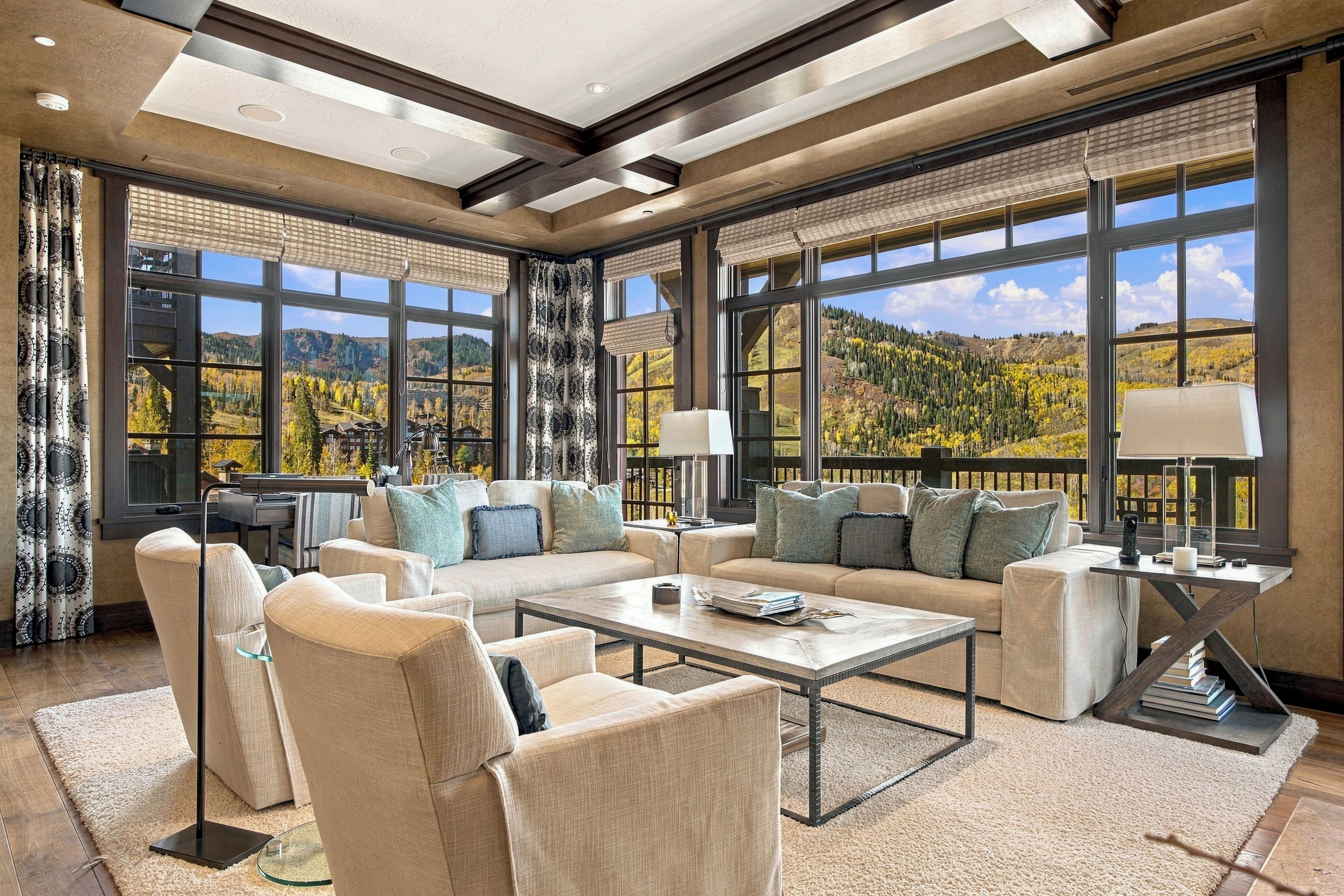A spacious living room with a large sofa, armchairs, a coffee table, and a fireplace.