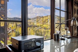 A printer on a desk with a view of a mountainous landscape through large windows. - Ski-in/Ski-out Luxury 3-Bedroom Retreat at Flagstaff Lodge! Epic Views, Hot Tub! (Park City)