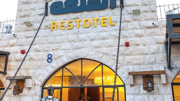 A stone building with a sign for the Restotel.