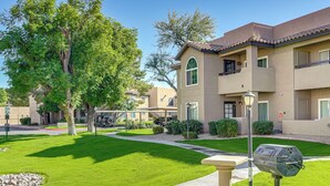 A residential building with a well-maintained lawn, a mailbox, and a clear sky. - Pool & Tennis Access! Condo in Central Scottsdale (Scottsdale)