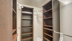 Un dressing avec des étagères ouvertes et une tringle pour suspendre les vêtements.