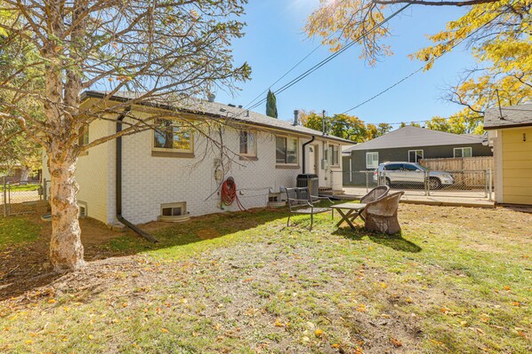 A residential house with a brick exterior, a covered patio, and a fenced yard. - Prime Belmar Access! Updated Unit w/ Office & Yard (Lakewood)