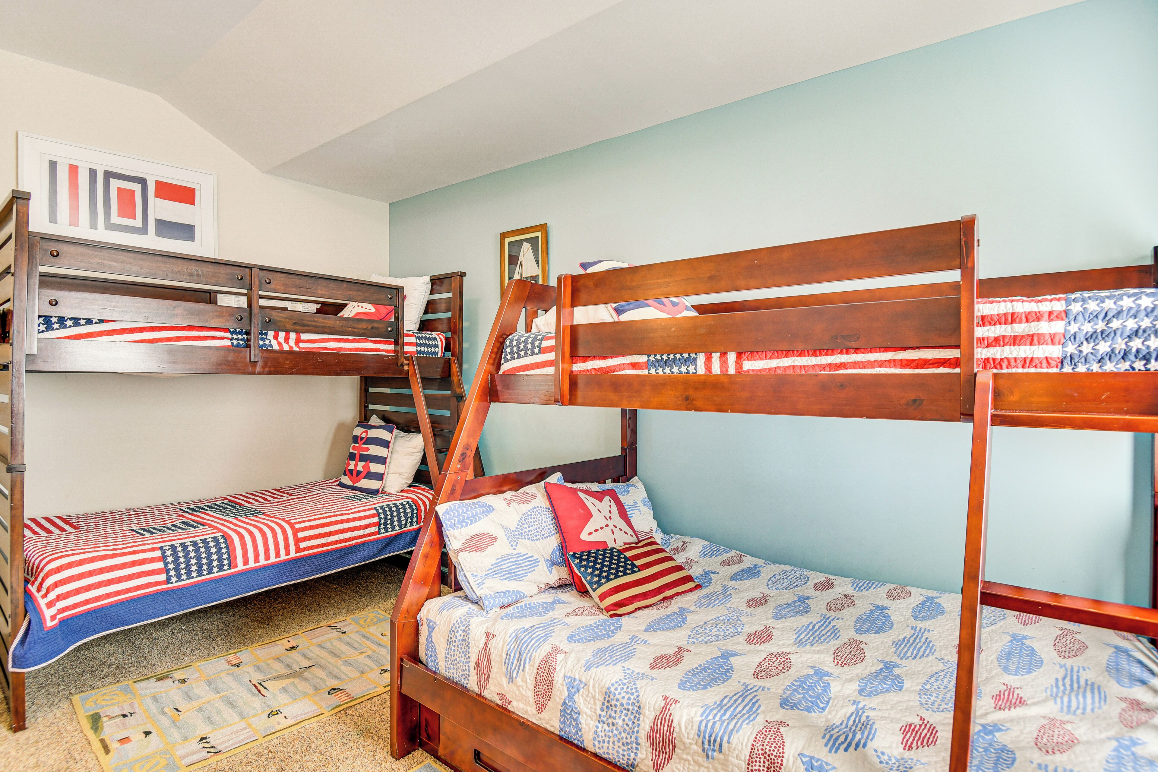 A room with bunk beds, each with a patterned bedspread.