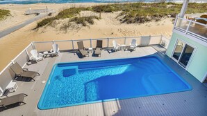 A pool area with lounge chairs and a view of the beach and ocean. - Blue Dolphin, Oceanfront Views! Sandbridge Home (Virginia Beach)
