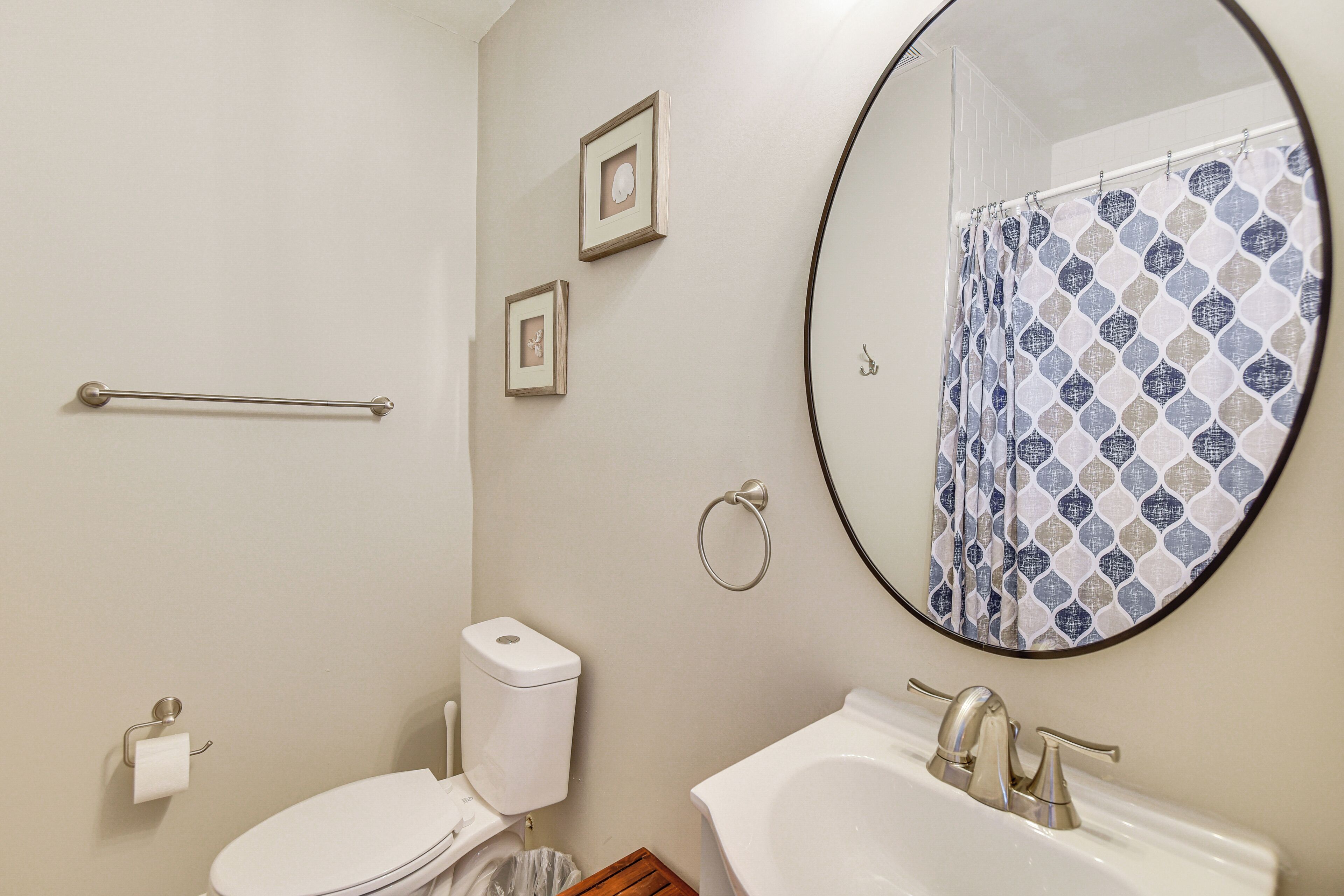 A bathroom with a toilet, sink, and a shower curtain.