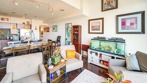 Un salón espacioso con comedor, un acuario y una cocina al fondo.
