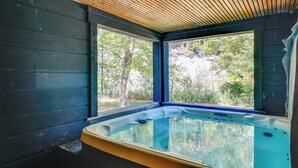 A hot tub in a room with dark walls and large windows. - Luxe 5,000 Sq Ft Retreat: 5 Mi to Stratton Resort (Jamaica)