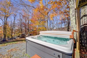 Ein Whirlpool in einer bewaldeten Gegend mit Bänken und einer Holzterrasse.