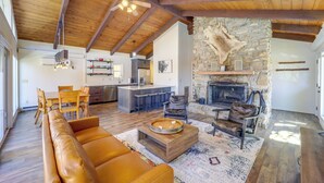 A spacious living area with a stone fireplace, wooden ceiling beams, and a leather sofa. - 2 Mi to Beech Mtn Resort: Family Home w/ Hot Tub! (Banner Elk)