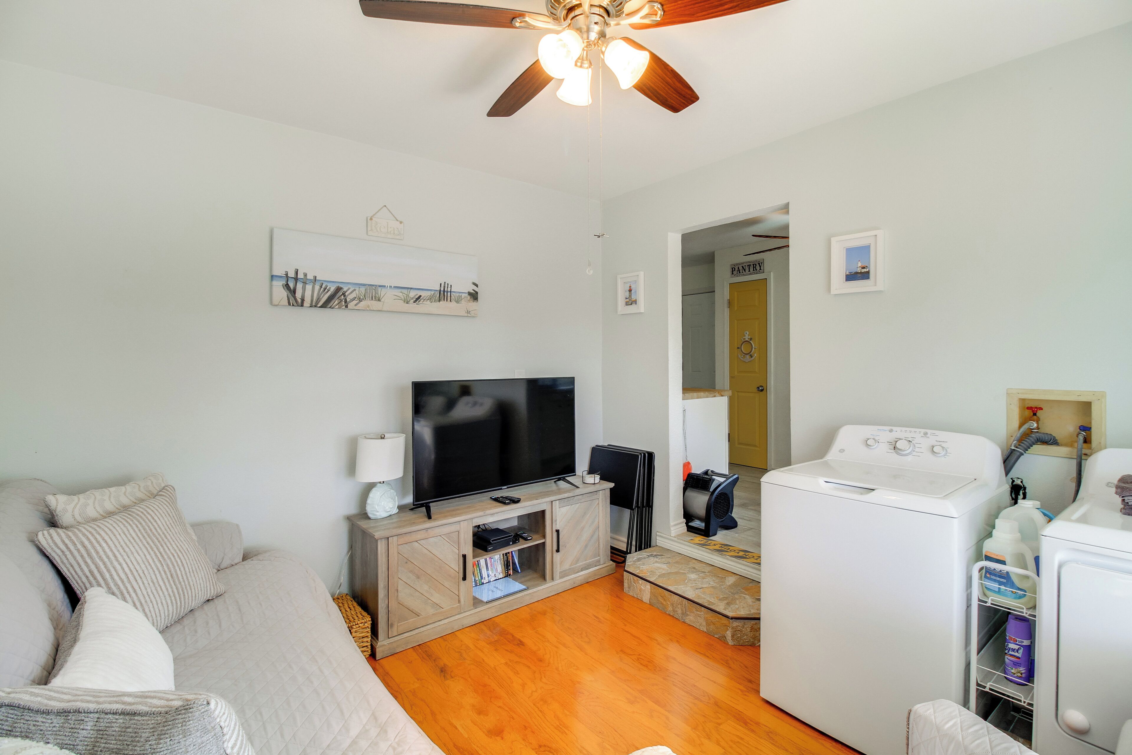 Ein Wohnzimmer mit Sofa, Fernseher und Waschmaschine.