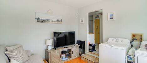 Ein Wohnzimmer mit Sofa, Fernseher und Waschmaschine.