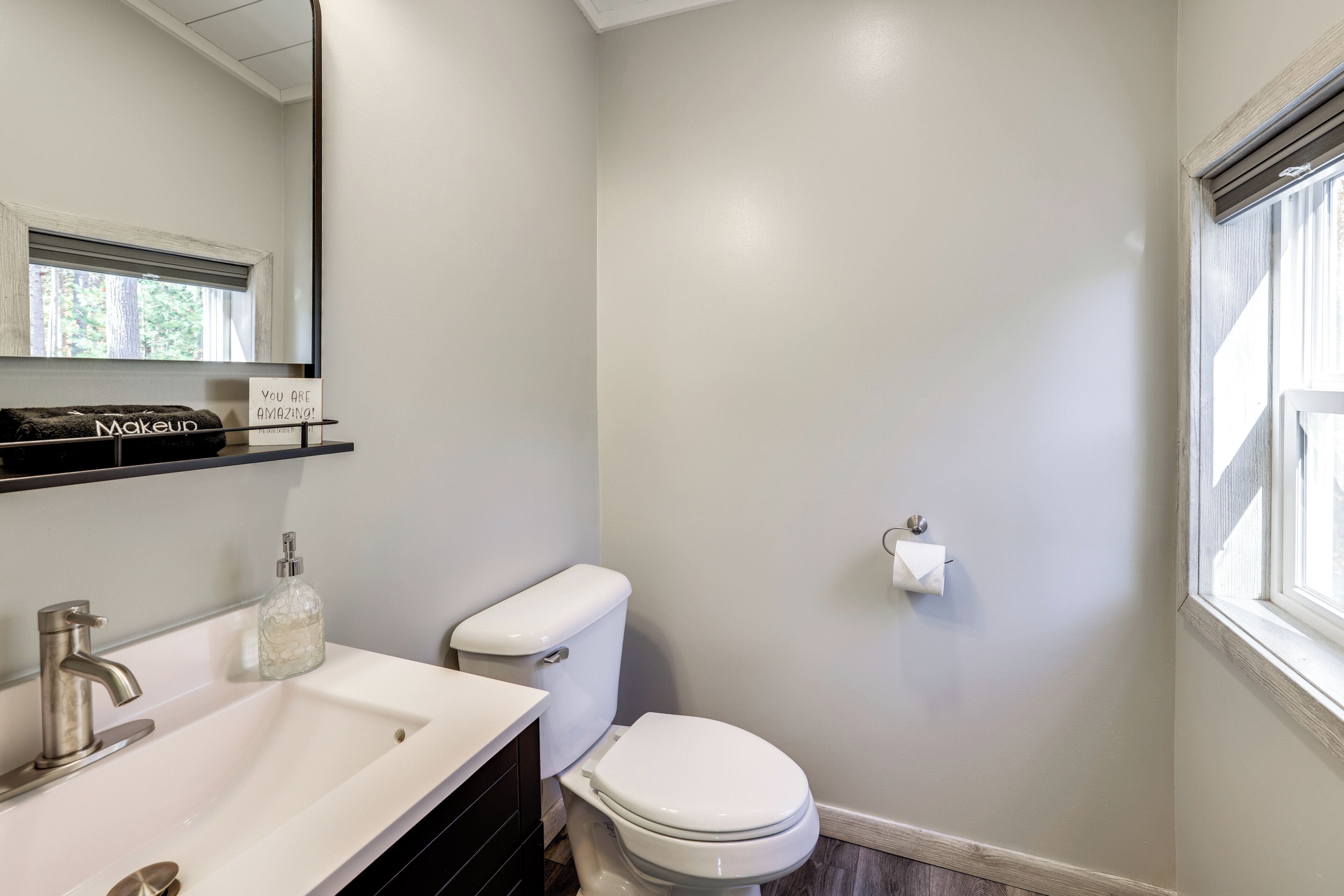 A bathroom with a white sink, a toilet, and a mirror.