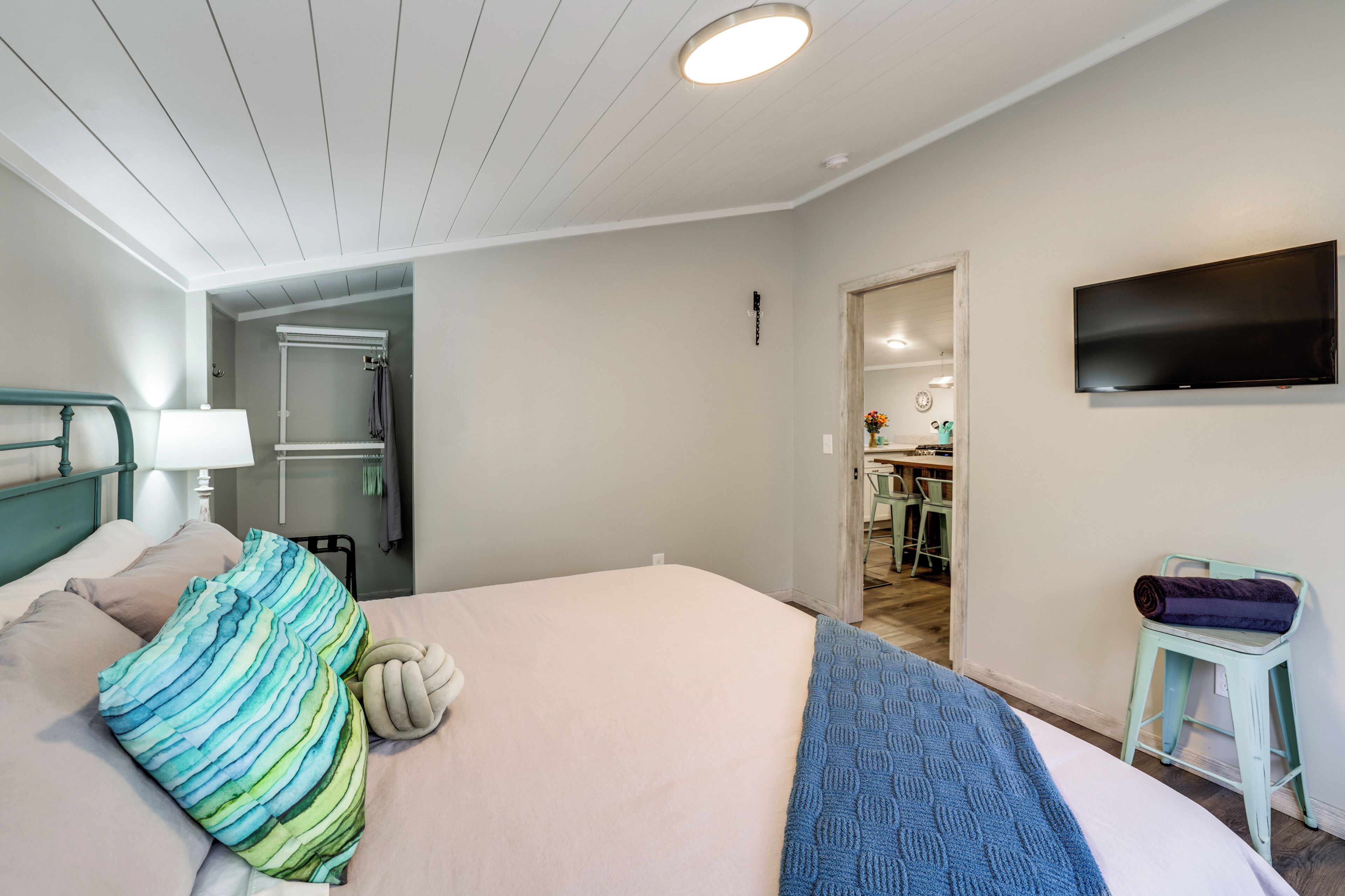 A hotel room with a bed, a TV, a small table, and a chair.