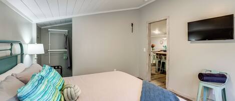 A hotel room with a bed, a TV, a small table, and a chair.