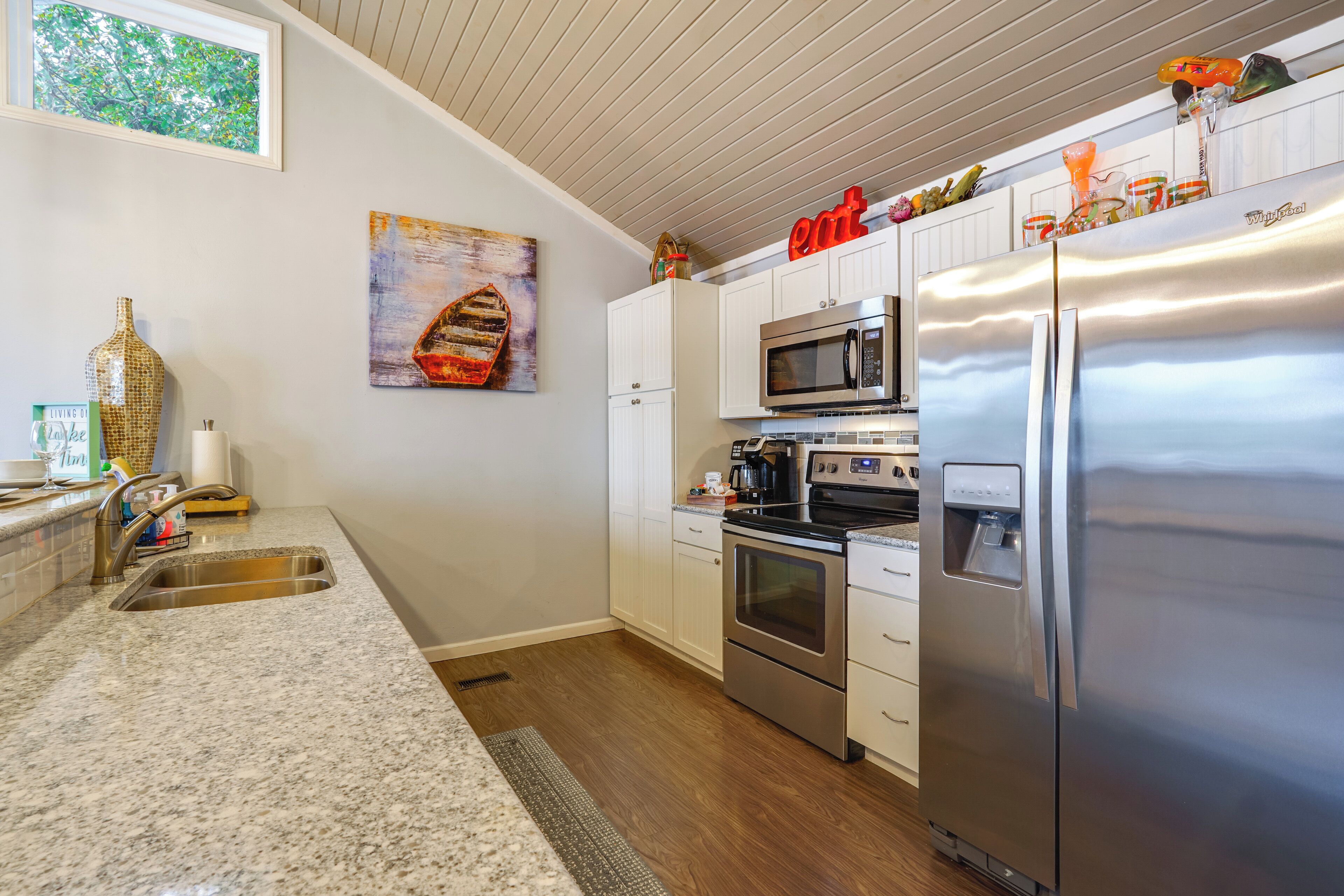 A modern kitchen with white cabinets, stainless steel appliances, and a granite countertop.