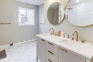 A bathroom with a double sink, gold fixtures, a large mirror, and a window. - 2 Mi to Uscg Academy! Convenient New London Home (New London)