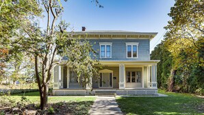 A two-story house with a front porch, a covered entryway, and a front yard with a pathway leading to the door.