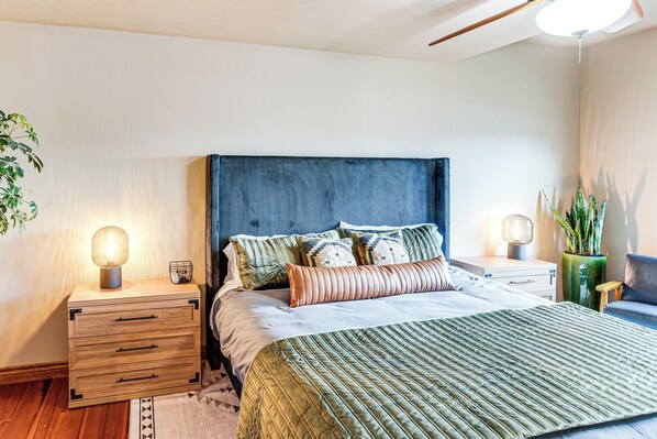 A modern bedroom with a large bed, wooden nightstands, and a ceiling fan. - Hike & Golf: Farmington Home 1 Mi to Animas River! (Farmington)