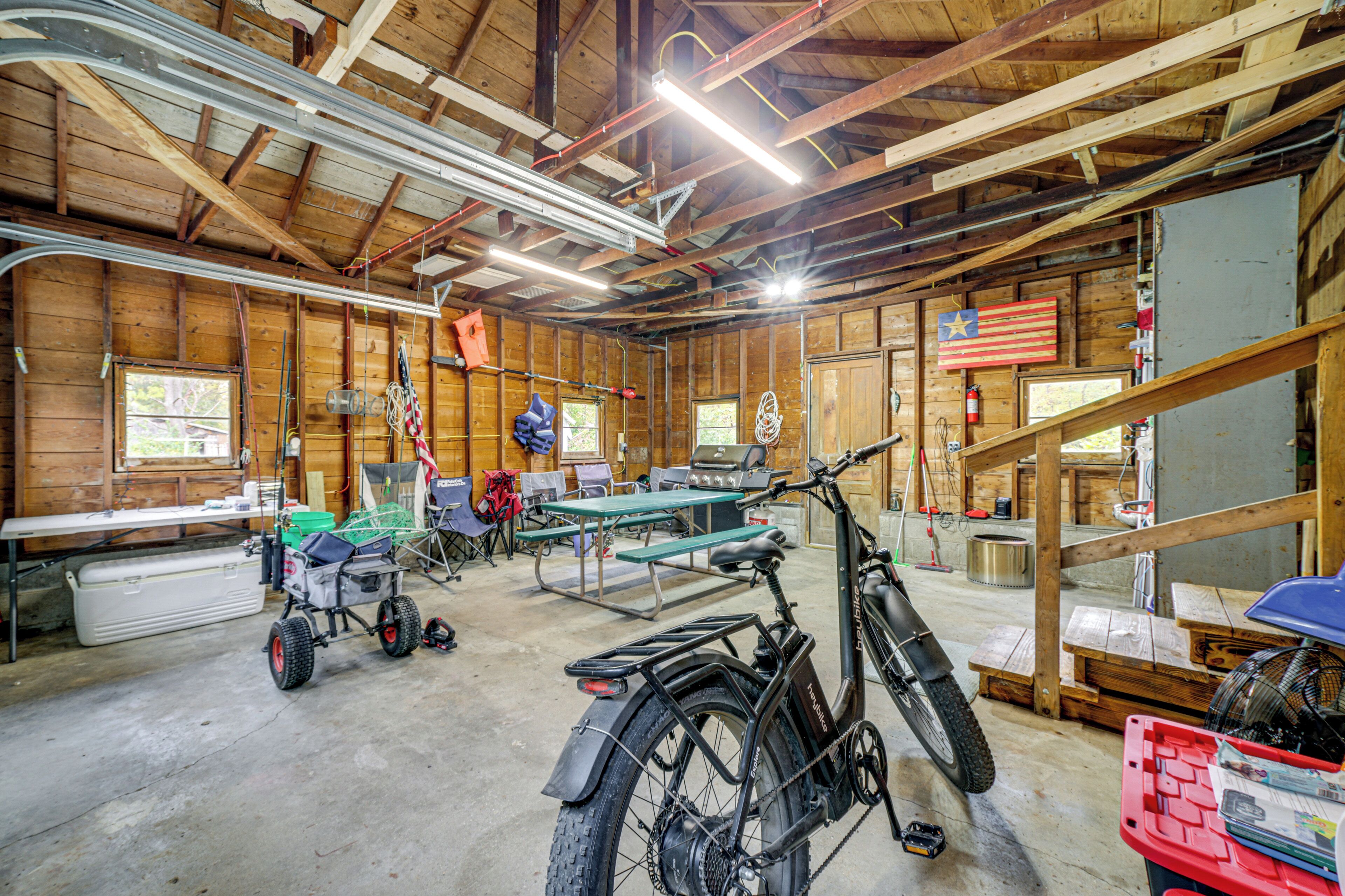 A spacious garage with a motorcycle, a table, and various tools.