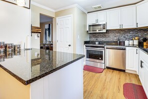 A kitchen with white cabinets, a granite countertop, a stainless steel oven, and a microwave. - 3 Mi to South Park: Quiet Pittsburgh Area Getaway (West Mifflin)