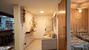 Een knus woongedeelte met een kitchenette, een zithoek en een slaapkamer met twee bedden.
