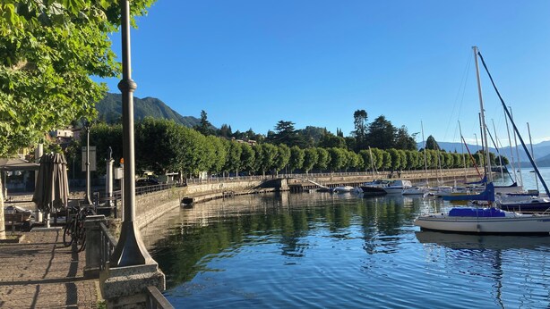 A marina with boats docked, a stone pathway, and a statue. - Villa Giulia - Vista Verde at 5 min from  the lake (Porto Valtravaglia)