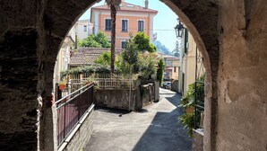 An arched stone passageway leading to a building with a tiled roof. - Villa Giulia - Vista Verde at 5 min from  the lake (Porto Valtravaglia)