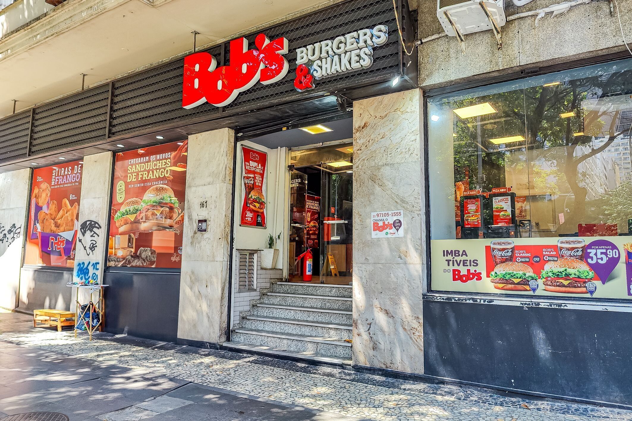 A restaurant with a sign reading 'Bobs Burgers & Shakes' and a menu board advertising burgers and shakes.