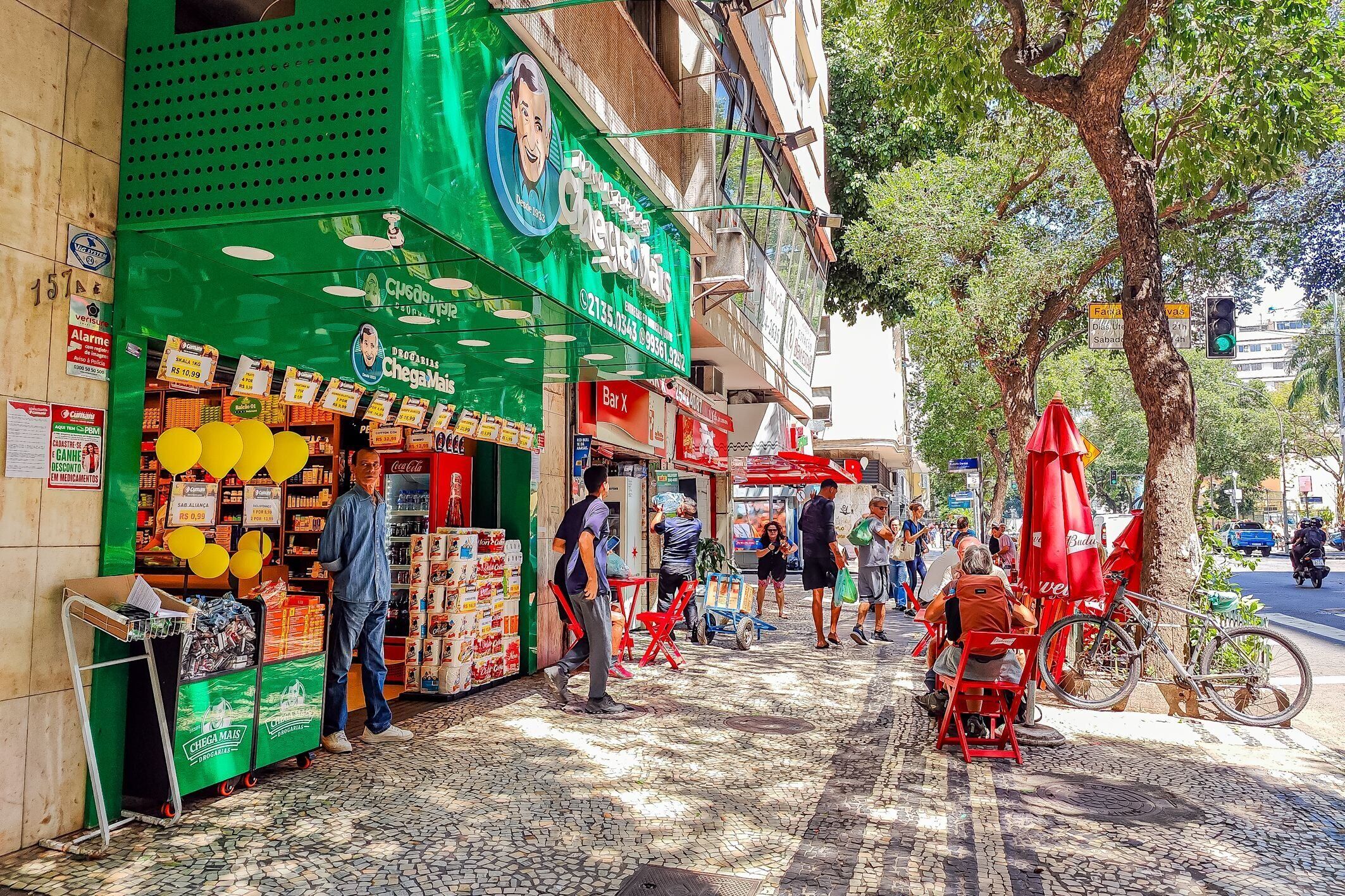 Une scène de rue avec une devanture de magasin verte, un vélo et un arbre.