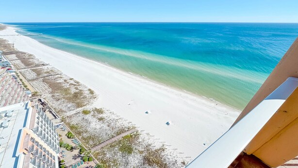 A beach view with a clear sky, a sandy beach, and a calm sea. - Penthouse 4BR, Beachfront!, Lazy River/Slide! (Orange Beach)