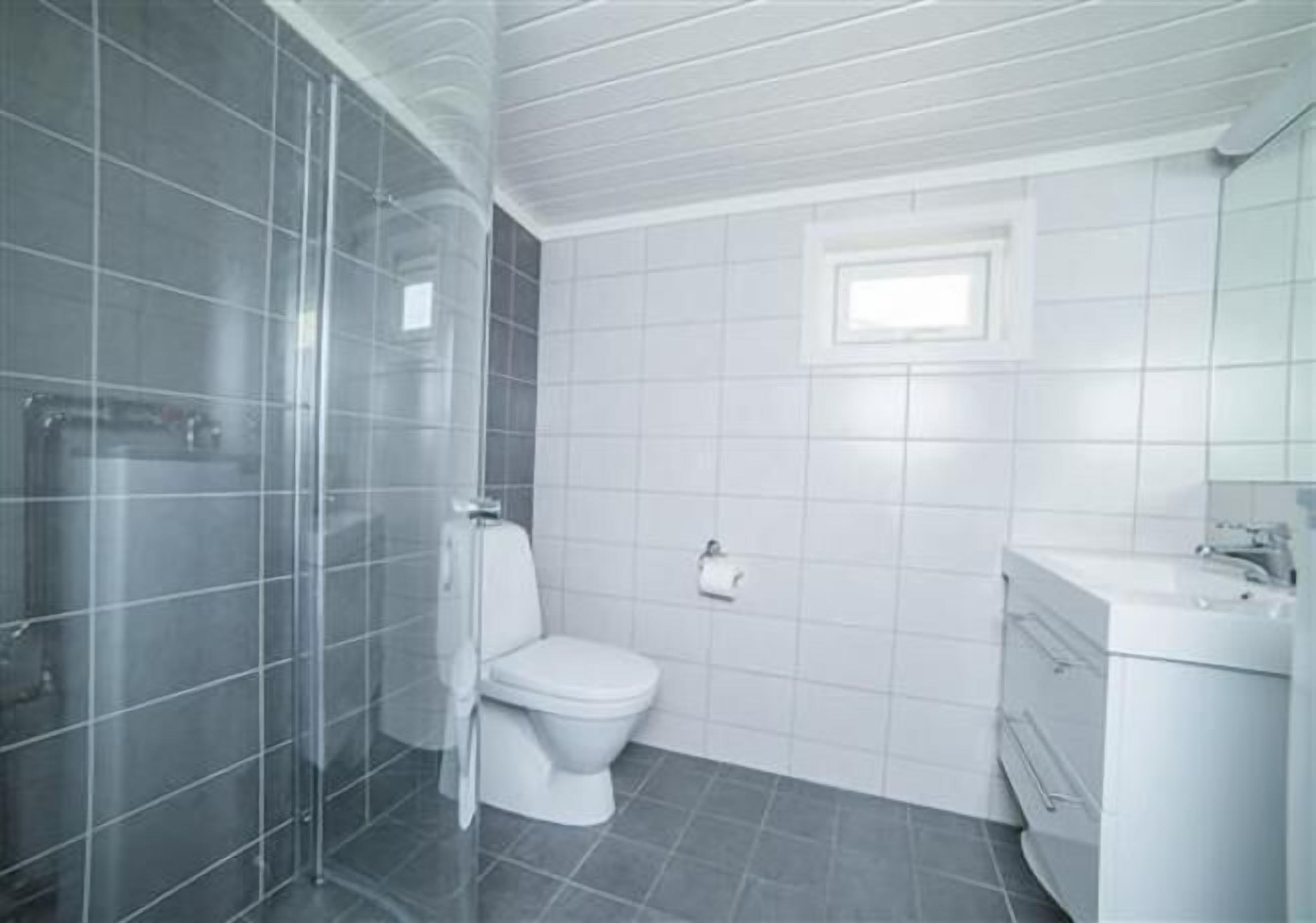 Un baño con inodoro, lavabo y zona de ducha.