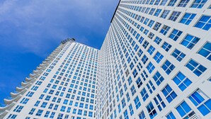 A tall, modern building with a grid of windows and a clear blue sky in the background. - w Dreamy 1BR w Stunning Cinta Costera Views (Panama City)