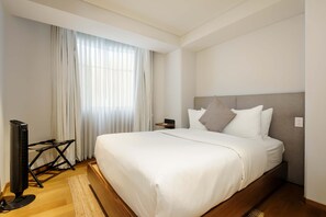 A modern hotel room with a large bed, a flat-screen TV, and a window with sheer curtains. - w Radiant 2BR in Roma Norte (Mexico City)