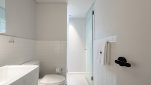 A modern bathroom with a bathtub, toilet, and glass shower enclosure. - w Awesome 2BR in Roma Norte (Mexico City)