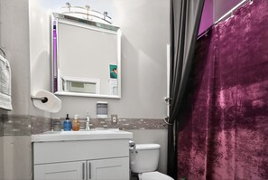 A bathroom with a white sink, mirror, and toilet. - New! Huge Downtown Loft - Game Room - Free Parking (Detroit)