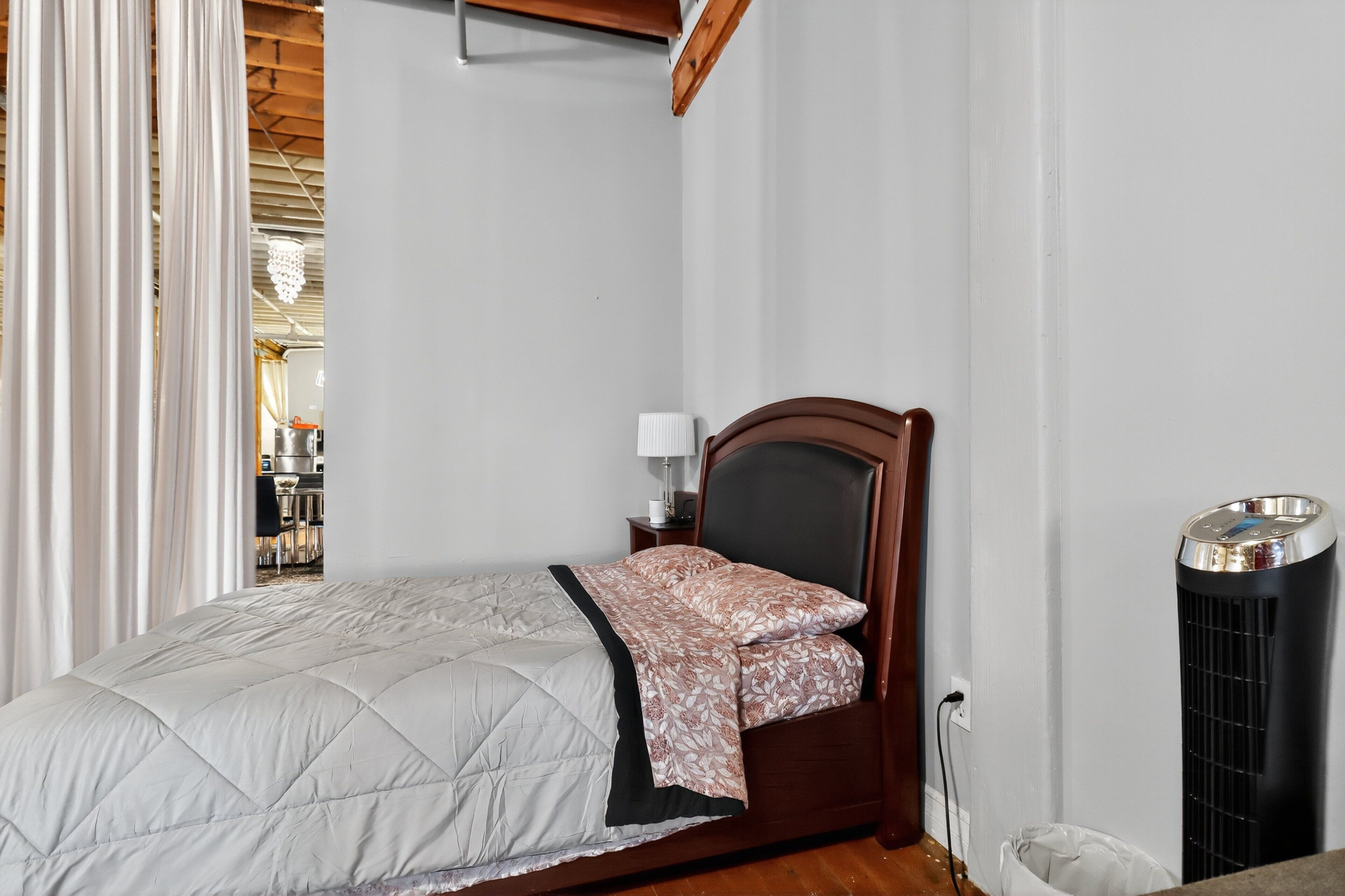 Une chambre à coucher avec un lit, une table de chevet, une lampe et un radiateur.