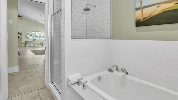 A modern bathroom with a bathtub, shower, and a glass-enclosed shower area.