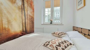 Ein Schlafzimmer mit einem Bett, einem Fenster mit Blick auf Bäume und einer Heizung.